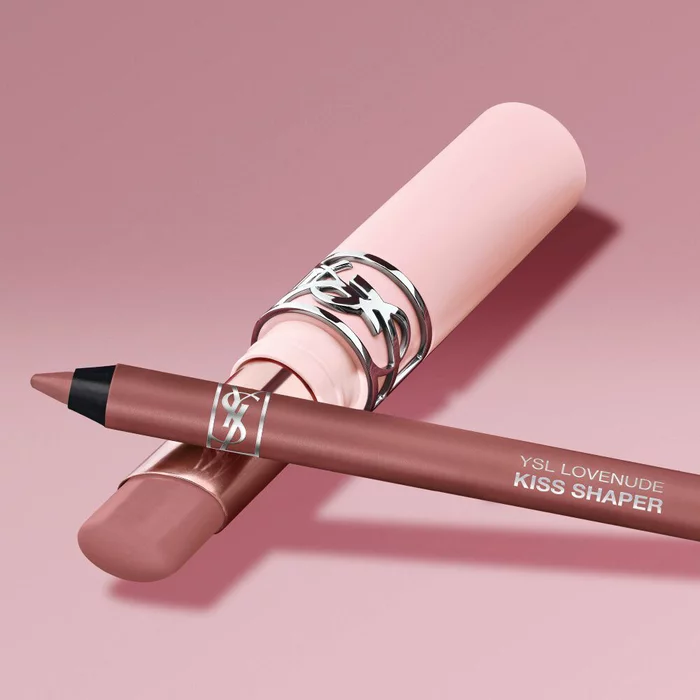 YSL LOVENUDE Kiss Shaper and Lip Blusher in Shade 1, digital still life on a soft pink background.