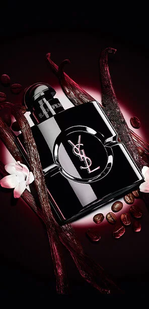 Le flacon Black Opium Le Parfum en noir brillant, entoure de gousses de vanille noire et de jasmin blanc.