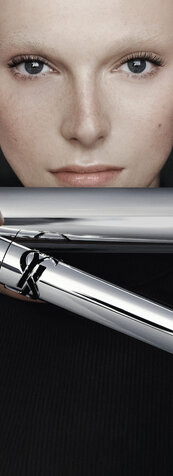 YSL Lash Latex Mascara in sleek silver packaging, showcasing rich black texture on a reflective grey background.