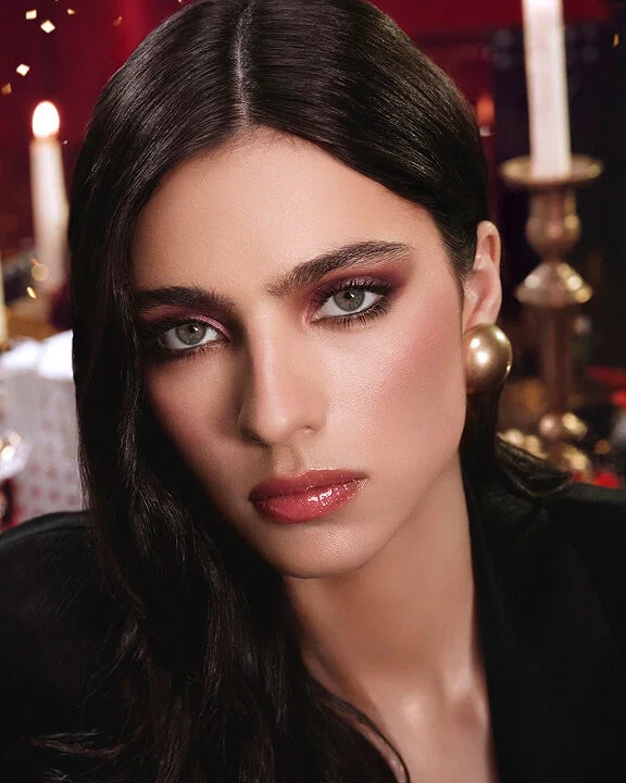 Glamorous model showcasing warm burgundy eyeshadow and defined eyes for the Holiday season.