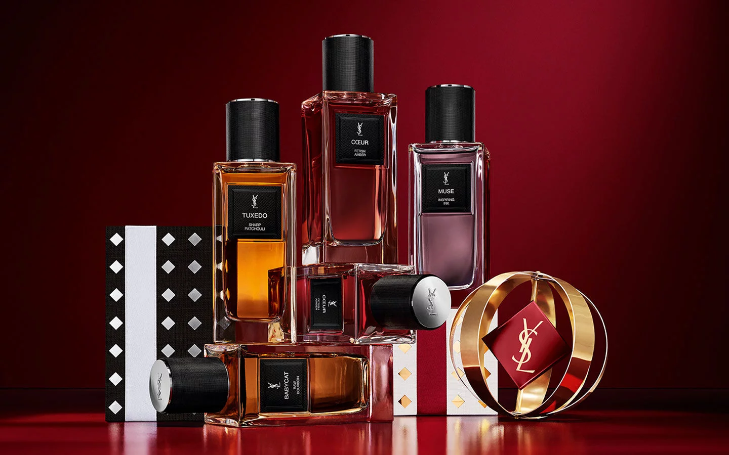 YSL Le Vestiaire des Parfums luxury bottles set on patterned Holiday gift boxes.