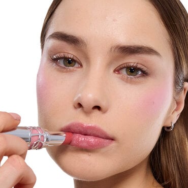 Najma applying YSL LOVESHINE Lipstick shade 215 to her shimmering lips, showcasing a radiant finish.