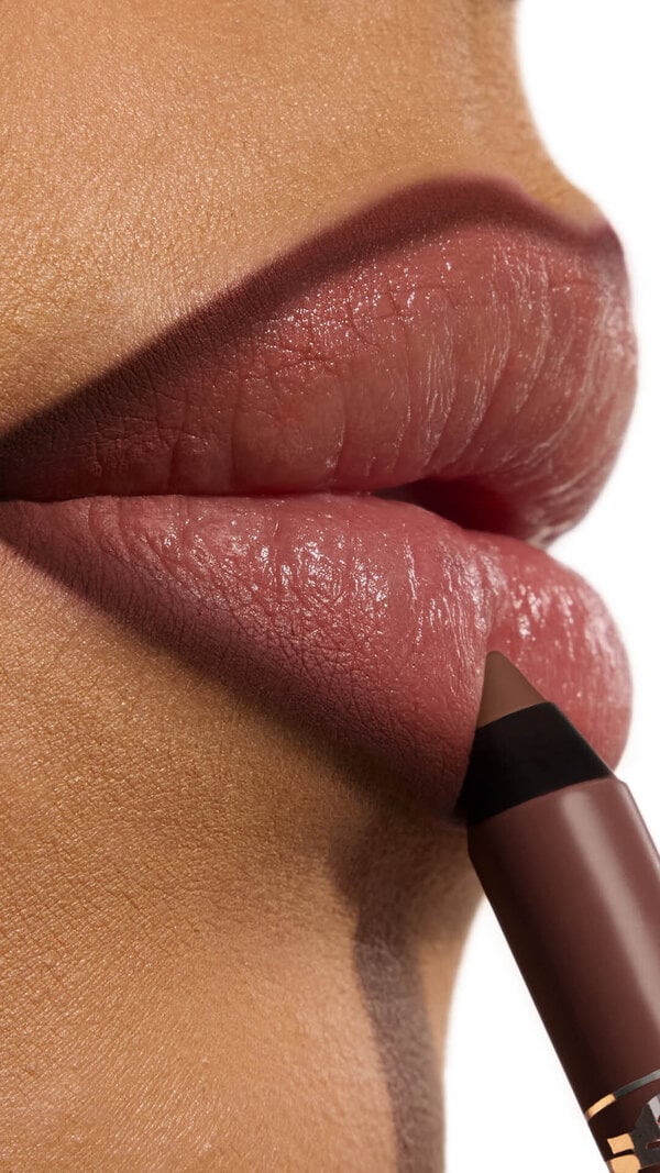 Ehlana applying YSL LOVENUDE Kiss Shaper 26 in Shade 110, a close- up of her lips.