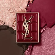YSL Couture Mini Clutch palette set against a textured background of shimmering eyeshadow powders of #1982 Burgundy Millesime.