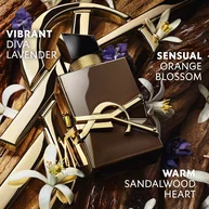 The YSL Cassandre gold rests on raw sandalwood, adorned with white orange blossoms and lavender, with text evoking the sensuality, vibration and energy of sandalwood.