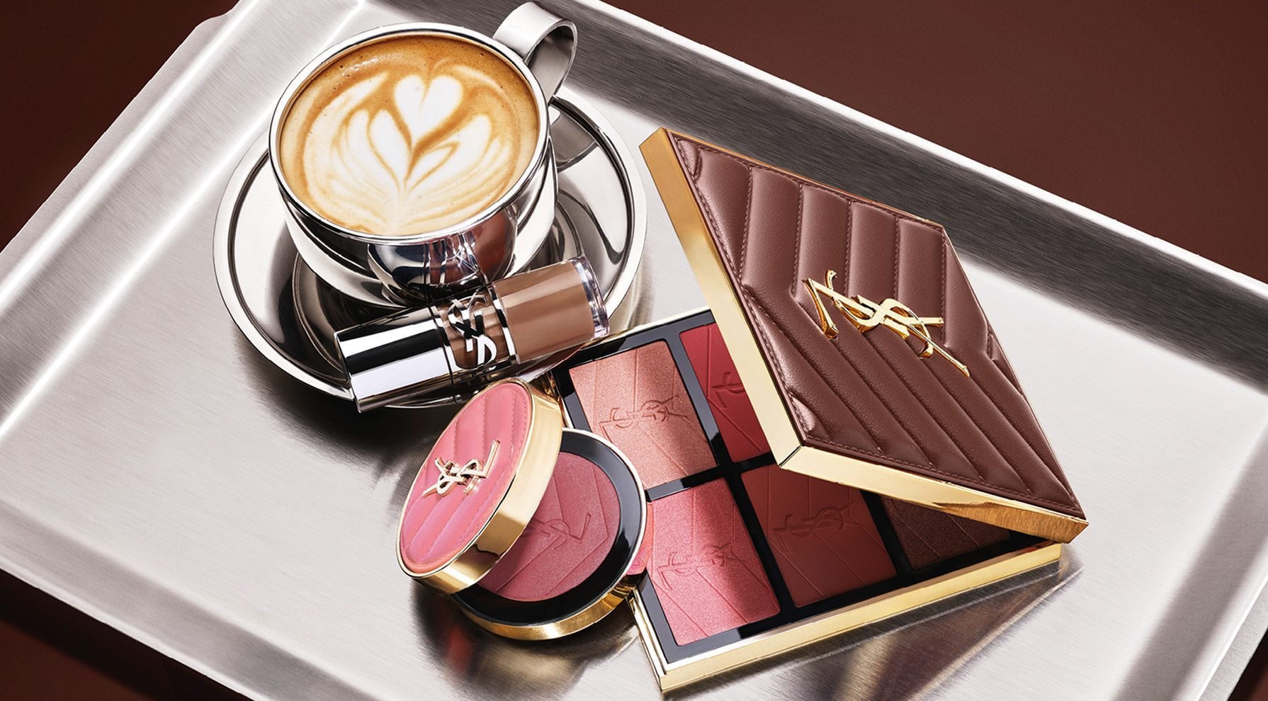 YSL Fall Drop latte makeup collection with Loveshine Lip Oil, Face Palette and Make Me Blush and a cup of coffee on a silver tray