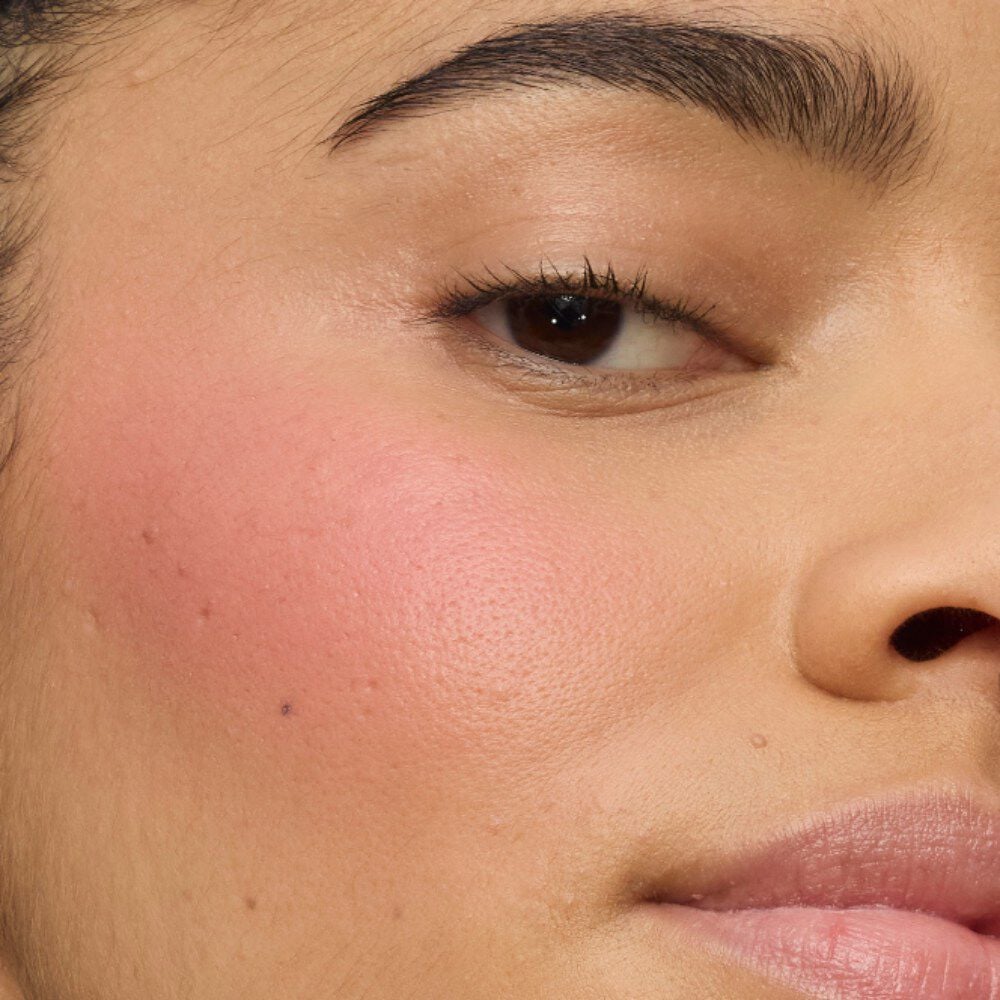 Close-up of a model's cheek showcasing the ultra-creamy finish of YSL Make Me Blush Lifted Glow Cream Blush in shade #44 Nude Lavallière for a vibrant, buildable lifted glow.