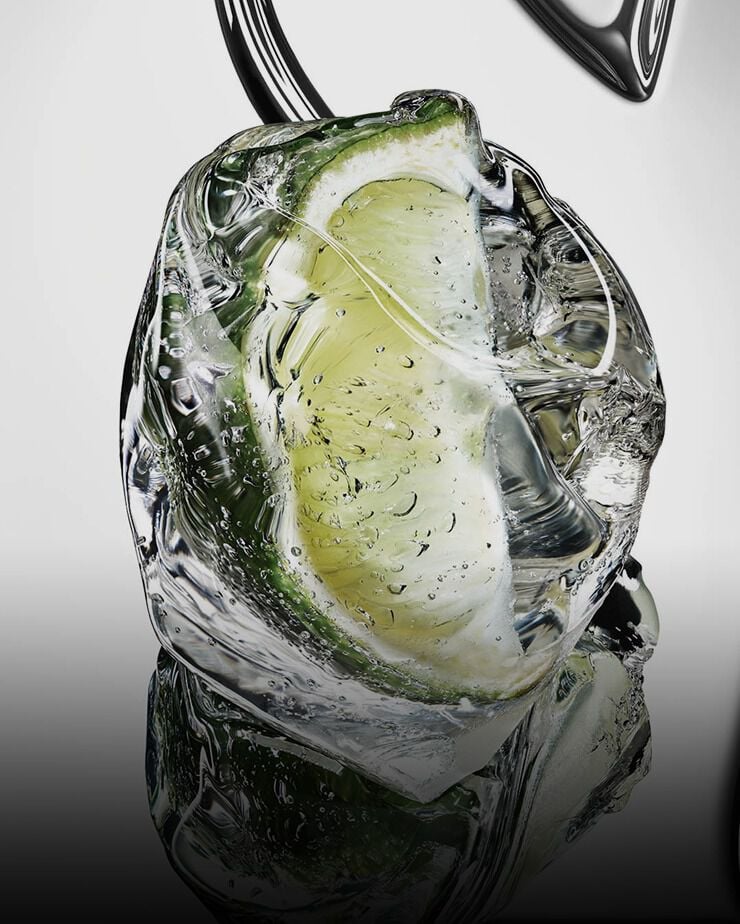 Fresh green bergamot fruit cut in half with water droplets on a reflective YSL Cassandre
background.