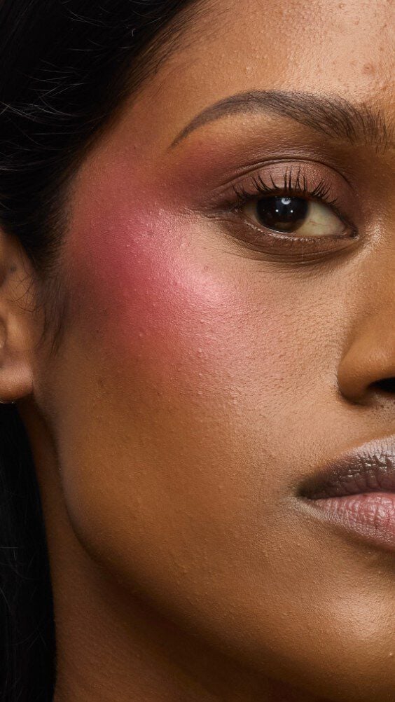 Close-up of a model's cheek wearing the Make Me Blush routine: Powder #66 Fuchsia Fizz layered with Cream #86 Raspberry Glaze for a vibrant, juicy finish.