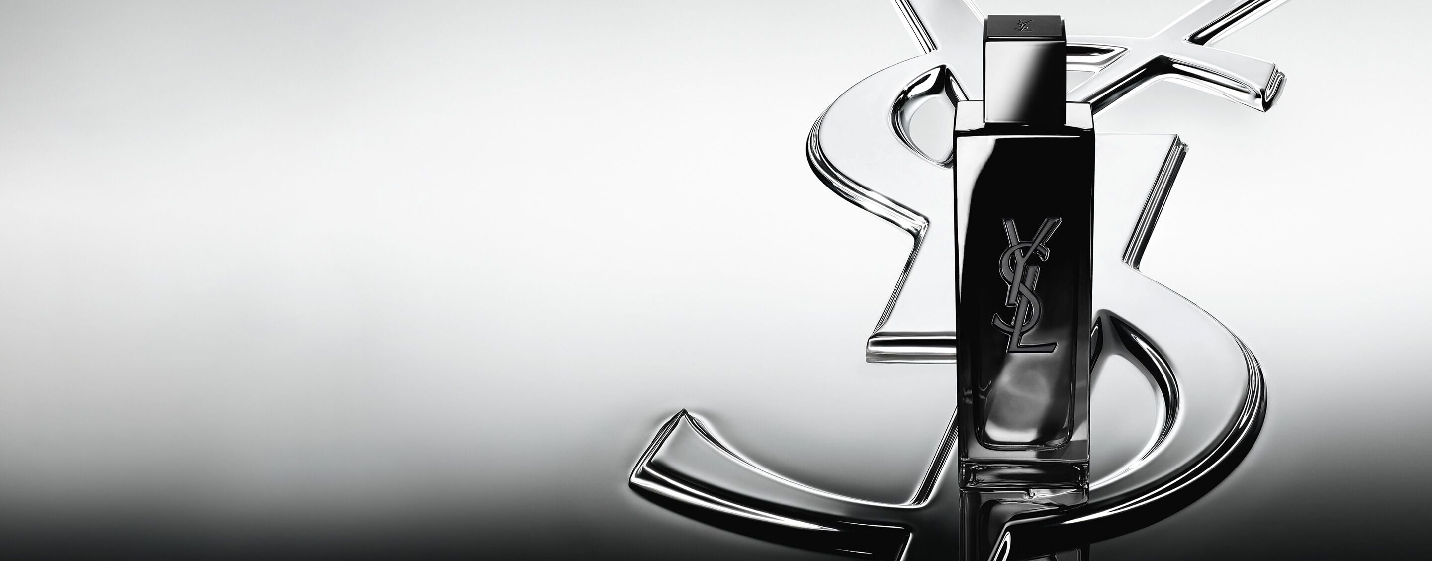 MYSLF Eau de Parfum bottle standing on a large YSL Cassandre logo with a reflective mirror
effect.