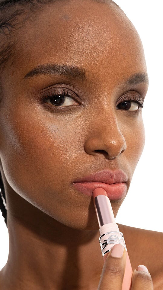 Le mannequin Zahara appliquant le YSL LOVENUDE Lip Blusher en teinte 4 sur ses lèvres nude rosées.