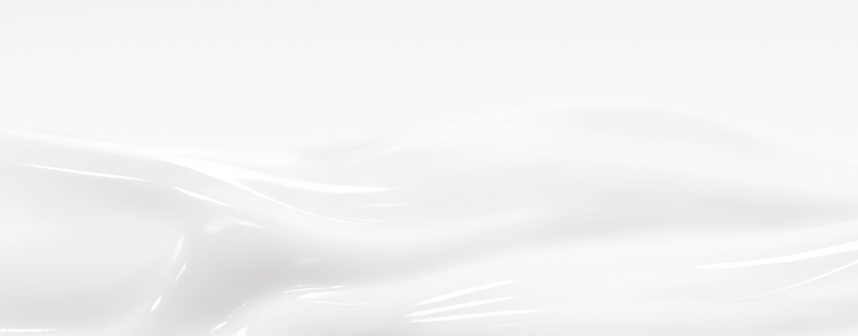 Gros plan de la texture crème blanche et soyeuse Care Crush formant des vagues lisses.