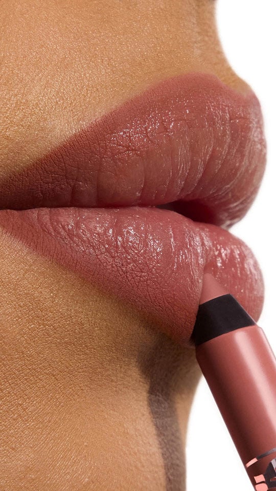 Ehlana applying YSL LOVENUDE Kiss Shaper in Shade 103, a close-up of her lips.