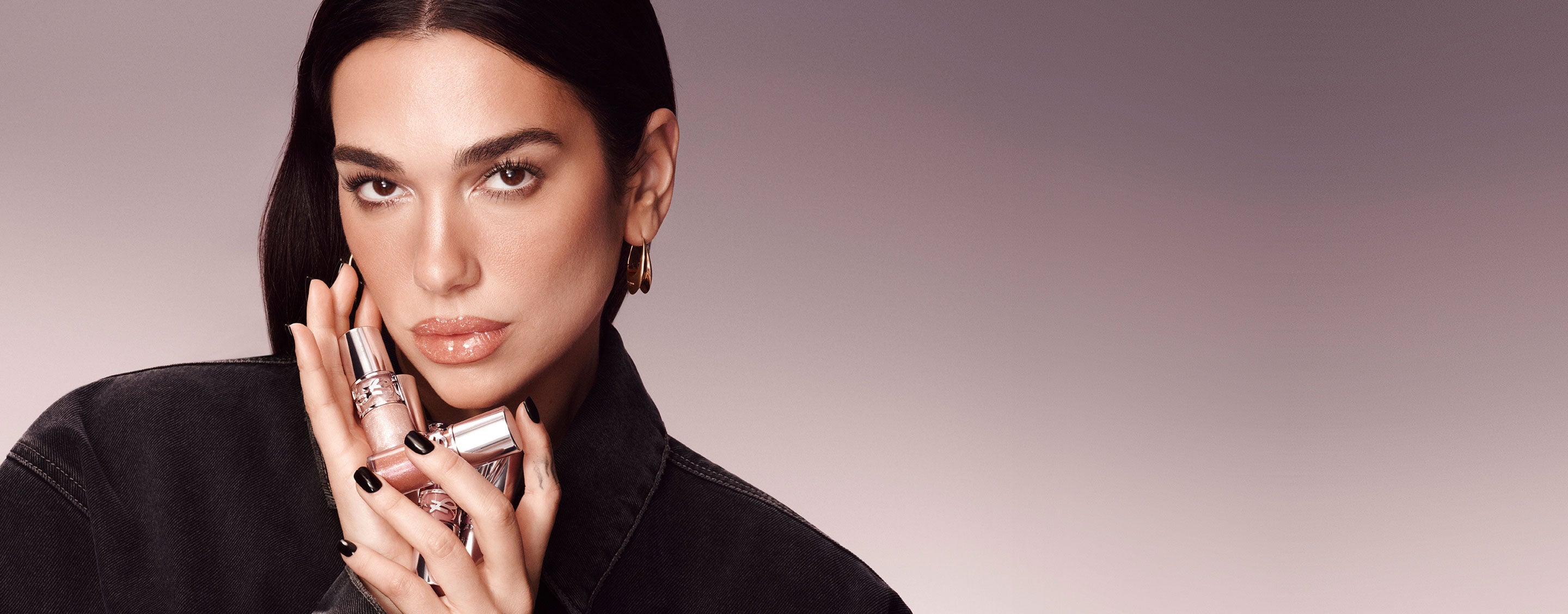 Dua Lipa holding several YSL Loveshine Lip Oil Gloss packshots